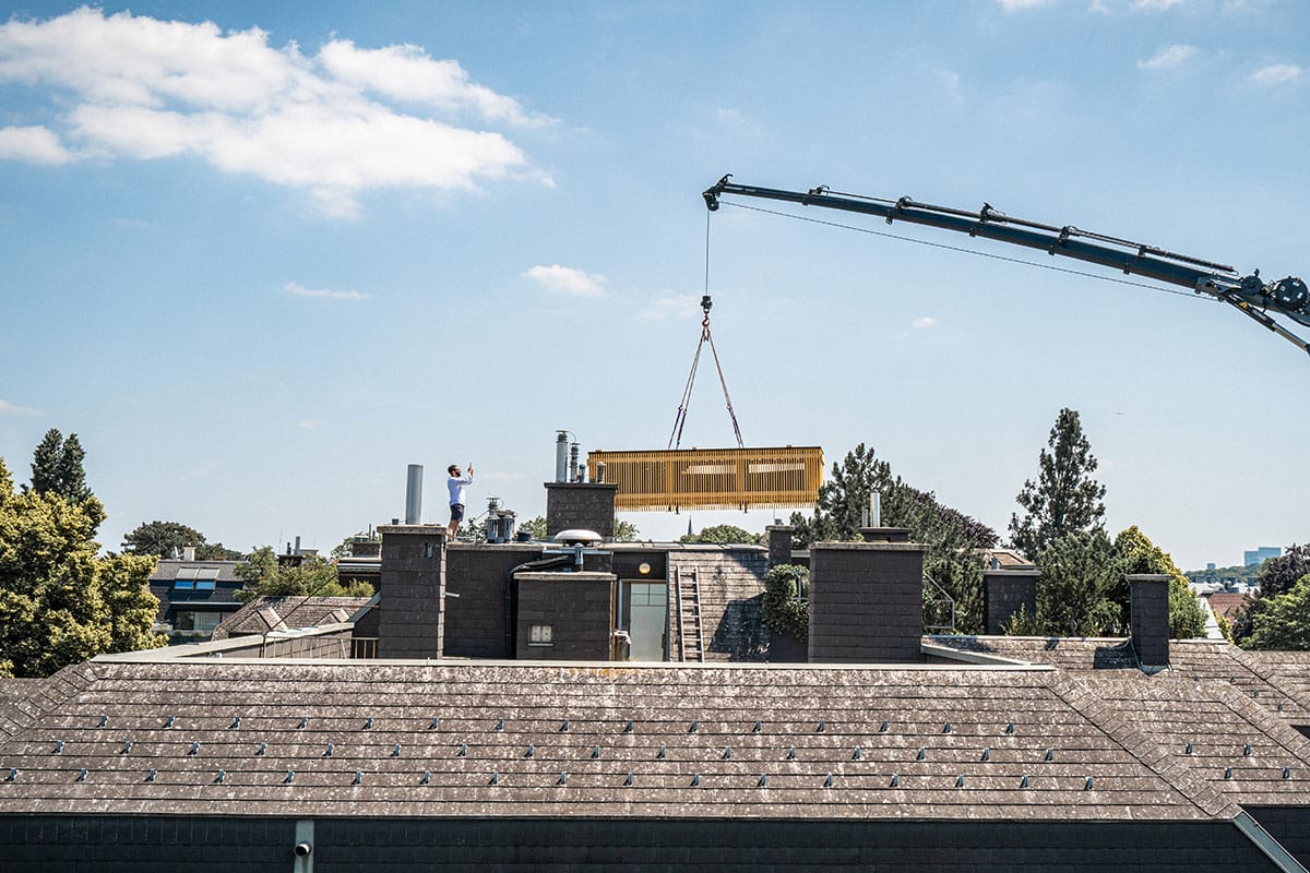 Crane placing a module onto the roof of an existing Viennese building